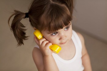 Portrait of a small girl talking on phone