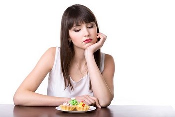 Dieting woman in front of cake